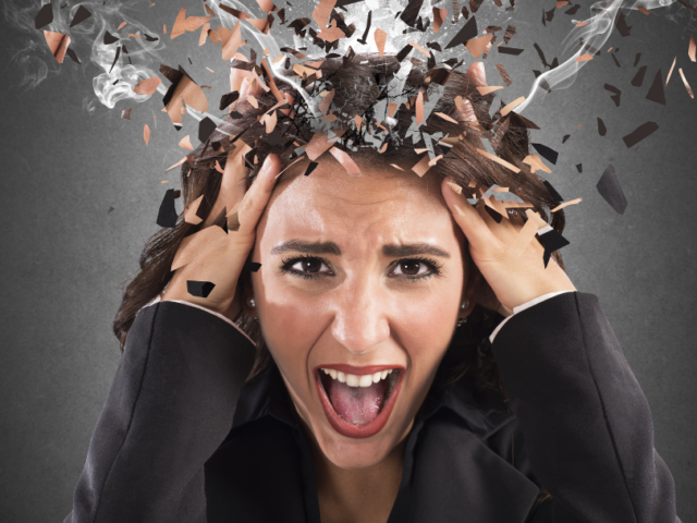 Woman clutching her head due to feeling stressed